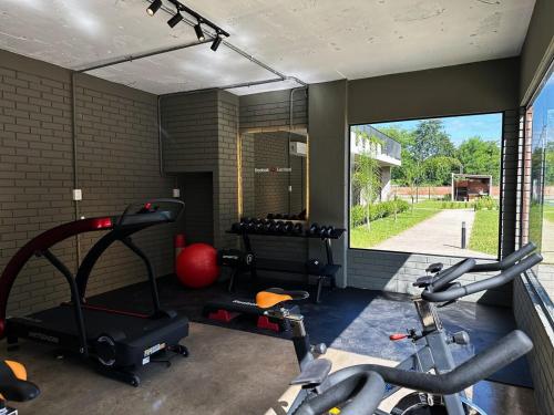 a gym with two exercise bikes and a large window at Apartamento en Luque cerca de Asunción 219 in Luque