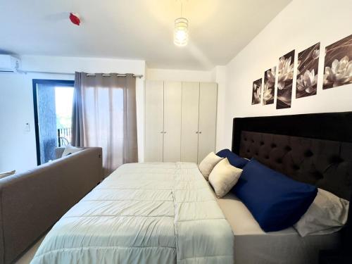 a bedroom with a large bed with blue pillows at Apartamento en Luque cerca de Asunción 219 in Luque