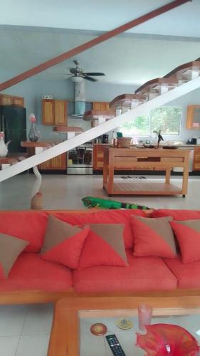 a living room with a red couch and a table at Dominical Beach 15 min Private Retreat Casa Grande in Platanillo