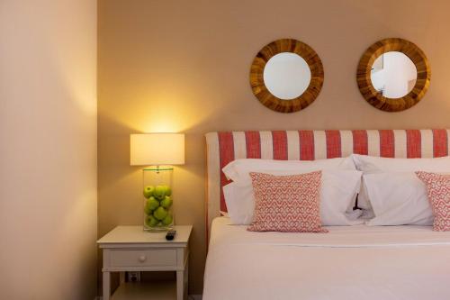 a bedroom with a bed and two mirrors on the wall at Pousada de Sagres in Sagres