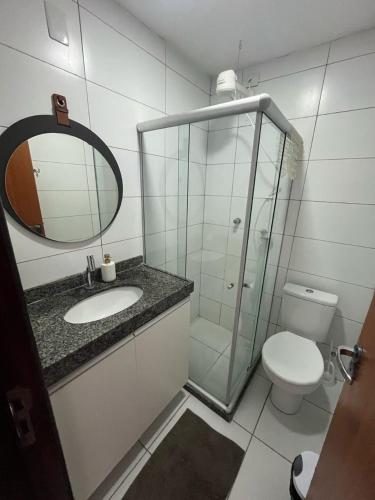 a bathroom with a sink and a toilet and a mirror at Flat Divina Paz Monte Castelo in Sairé