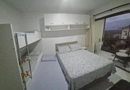 a small bedroom with a bed and a window at Flat Divina Paz Monte Castelo in Sairé