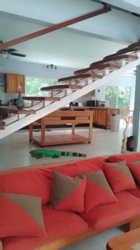 a living room with a red couch and a staircase at Dominical Beach 15 min Private Retreat Casa Grande in Platanillo