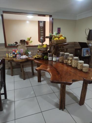 a kitchen with wooden tables and jars of food at Hotel Raízes in Bom Conselho
