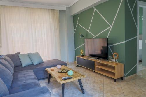 a living room with a blue couch and a tv at The perfect apartment 2 in Thessaloniki