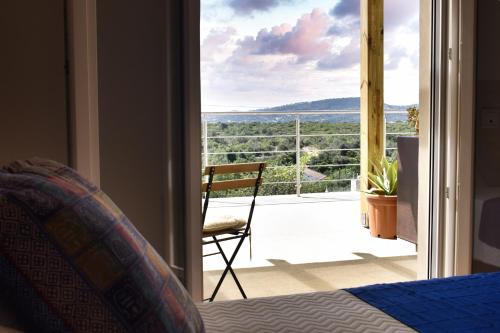 a bedroom with a bed and a view of a balcony at Heaven's Edge in São Brás de Alportel
