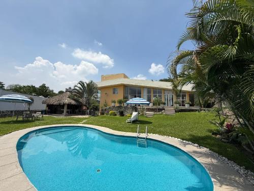 a large swimming pool in front of a house at Mirador de Águila in Temixco