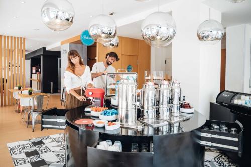 a man and a woman preparing food in a kitchen at Stay Hotel Faro Centro in Faro