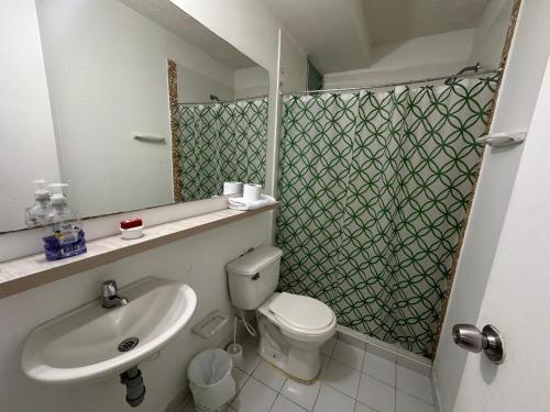 a bathroom with a sink and a toilet and a mirror at Apartamento Turístico Sol Vallenato 3 Hab in Valledupar