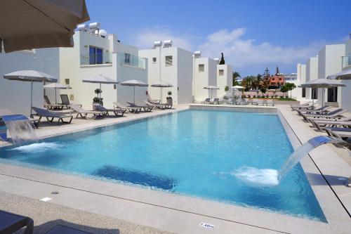 a swimming pool with a fountain in front of a building at Panas Villas in Ayia Napa