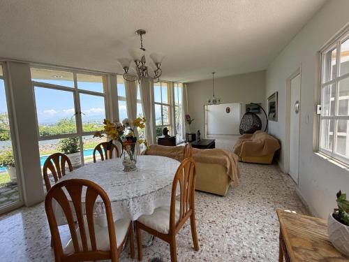 a dining room with a table and a living room with a couch at Mirador de Águila in Temixco