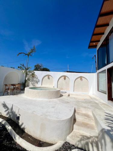 a white building with a patio with a table and chairs at Batur Cozy Bali in Kintamani