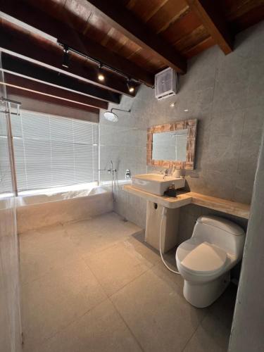a bathroom with a toilet and a sink and a tub at Batur Cozy Bali in Kintamani