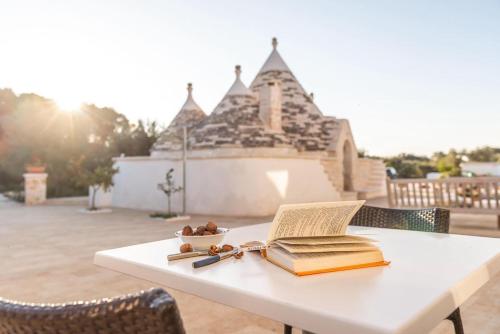 a table with two books and a bowl of fruit on it at Trullo Blue in Ceglie Messapica