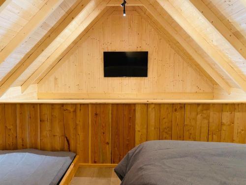 a bedroom with a roof with a tv on a wall at Franzlhof Chalets in Stainz