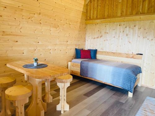 a room with a bed and a table in a cabin at Franzlhof Chalets in Stainz
