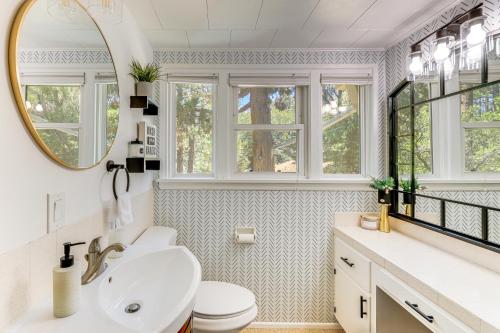 ein Bad mit einem Waschbecken, einem WC und Fenstern in der Unterkunft Trail Access and Snow Hill On-Site Big Bear Gem in Big Bear City