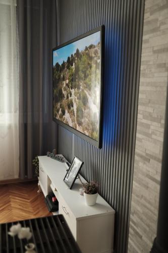 a painting hanging on a wall above a white desk at Apartman Silver in Jajce
