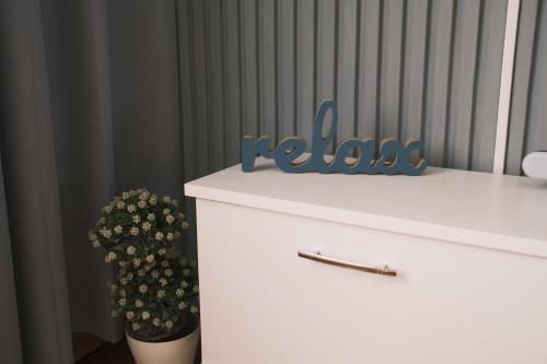 a white dresser with a potted plant on top of it at Apartman Silver in Jajce