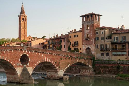a bridge over a river in a city with buildings at La casa ai Laghetti in Montorio Veronese