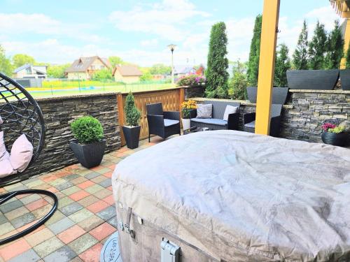 a patio with a bed and chairs and a stone wall at Apartmán pod Tatrami K 107 in Veľká Lomnica