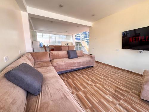 a living room with a large couch and a flat screen tv at Hotel Krammer en San Ramón, Selva Central in San Ramón
