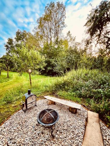 a fire pit with a bench and a grill at Maringotka Pomněnka in Pačejov