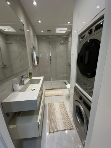 a bathroom with a sink and a washing machine at Квартира в SEEBREZE in Nardaran