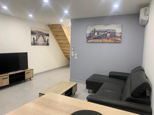 Una sala de estar con un sofá y un televisor de pantalla plana. en Noisy Villiers sur Marnes, en La Celle-sous-Gouzon