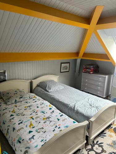 a bedroom with two beds and a dresser at Chambre CHEZ L'HABITANT in Le Gond