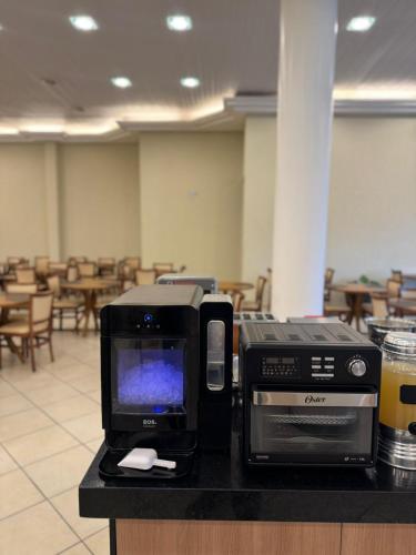 a computer monitor and a printer sitting on a counter at Imperador Hotel in Poços de Caldas