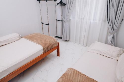 a bedroom with two beds and a window at Anjung Homestay & Event in Bukit Payong