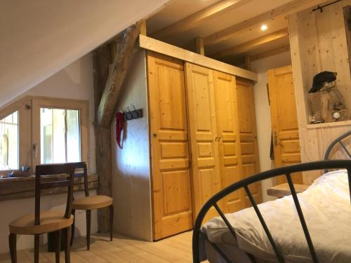 a bedroom with a bed and a refrigerator in a room at chalet de l'eau rousse in La Lechere