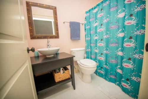 een badkamer met een wastafel en een toilet met een douchegordijn bij Newly Listed - Spacious Condo with Private Balcony in Beaufort