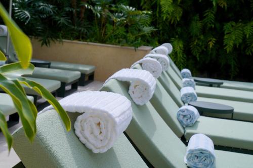 a row of green chairs with hats on them at HIGI Hotel in São Paulo