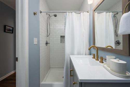 a white bathroom with a shower and a sink at Cozy 3-Bedroom Retreat in Charming Beaufort, SC in Beaufort