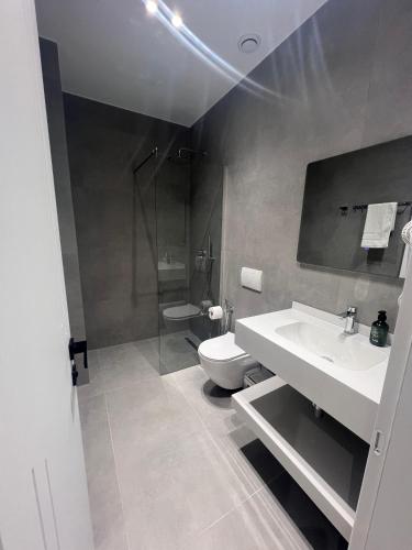 a bathroom with a sink and a toilet at Hotel Sisana in Vlorë