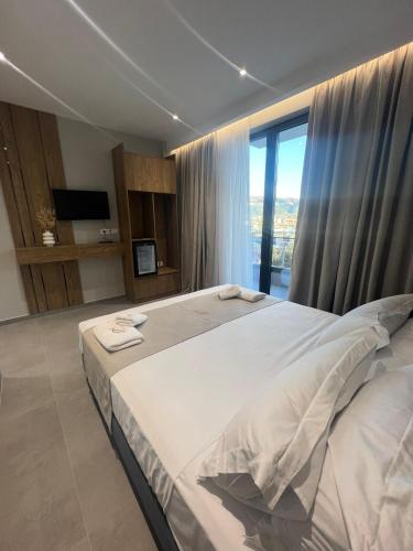 a bedroom with a large bed and a large window at Hotel Sisana in Vlorë
