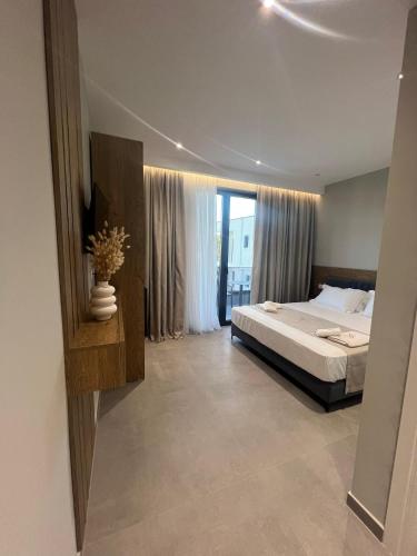 a bedroom with a bed and a large window at Hotel Sisana in Vlorë
