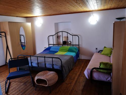 a bedroom with a bed and a chair at Holiday house Catela in Rakalj
