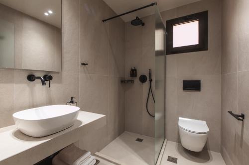 a bathroom with a sink and a toilet and a shower at Electra Hotel in Stavros