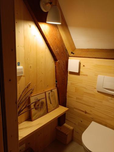 a bathroom with wooden walls and a toilet and a light at Bet & Jac in Meyronne