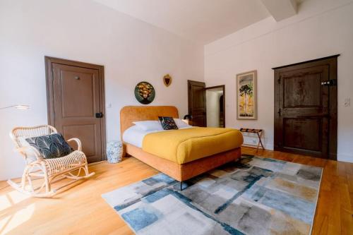 a bedroom with a bed and a chair in it at La Maison du Prévôt in Albi