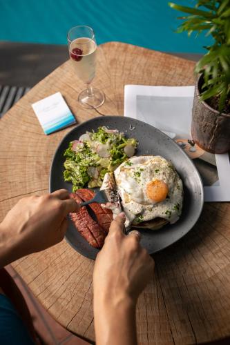 a person eating a plate of food with an egg and steak at Electra Hotel in Stavros
