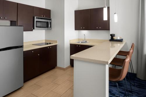 a kitchen with brown cabinets and a white refrigerator at Fairfield Inn & Suites Riverside Corona/Norco in Norco