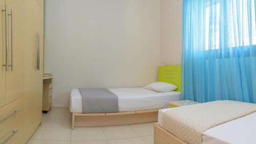 a bedroom with two beds and a blue curtain at Harmony House in Faliraki