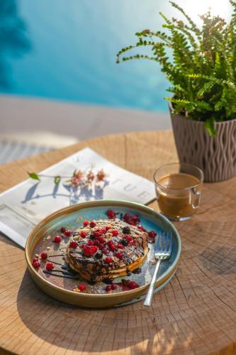 a plate of pancakes with berries on a table at Electra Hotel in Stavros