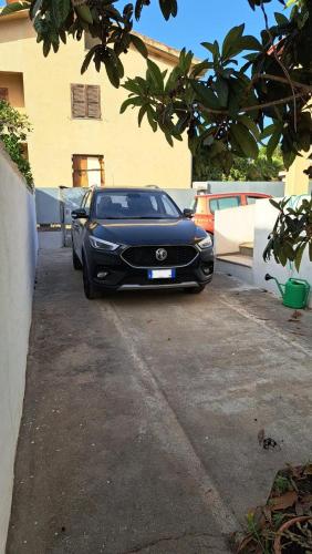 a black luxury car parked in a driveway at Casa del Sole - Trilocale con giardino in Carbonia