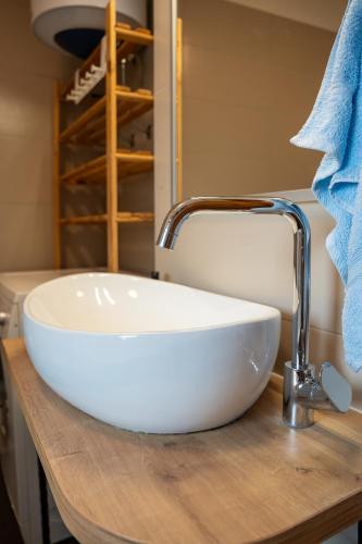 a white sink sitting on top of a wooden counter at Apartman Genio in Žminj