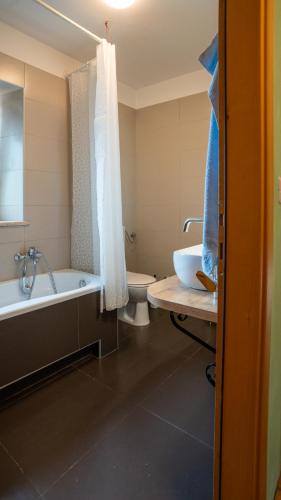 a bathroom with a tub and a toilet and a sink at Apartman Genio in Žminj